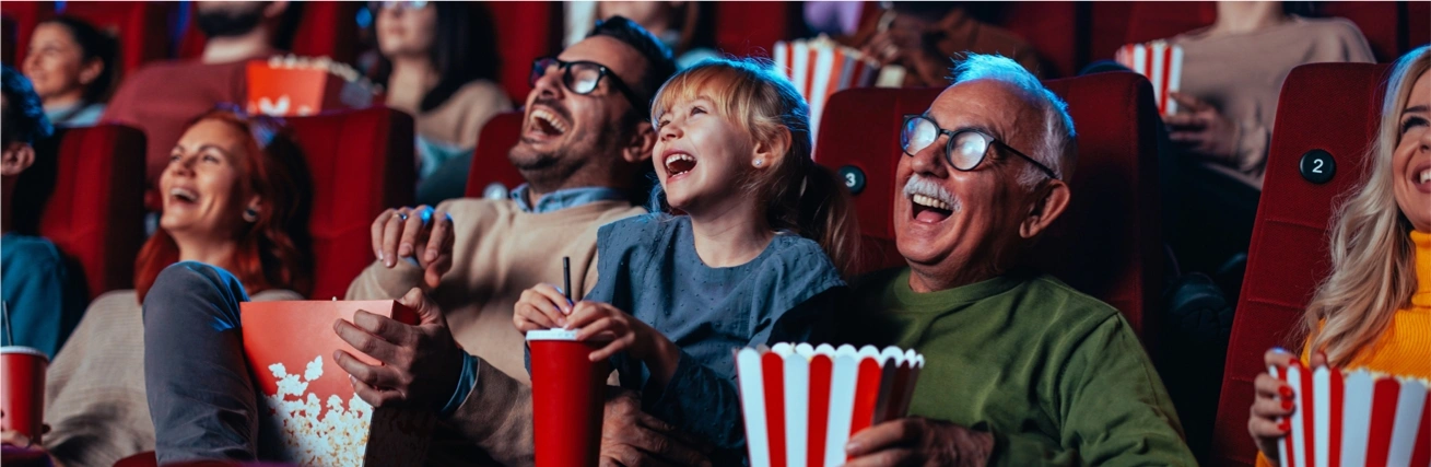 Family eating popcorn watching a film